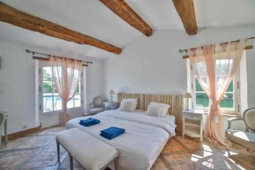 um quarto com uma grande cama branca e 2 janelas em Villa Lady em Les Portes