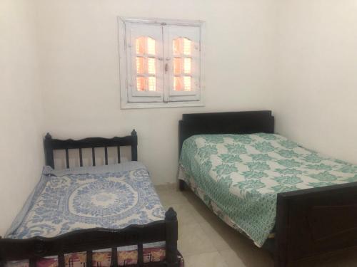 1 Schlafzimmer mit 2 Betten und einem Fenster in der Unterkunft برنس in Marsa Matruh