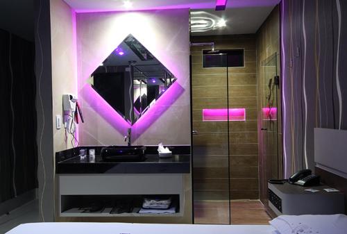 uma casa de banho com um lavatório e um espelho em Motel Deslize Curitiba em Curitiba