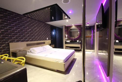 um quarto com uma cama grande e um espelho em Motel Deslize Curitiba em Curitiba