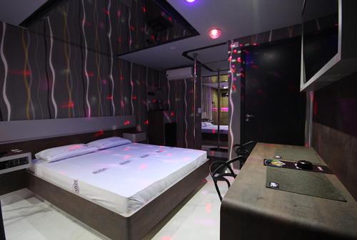 um quarto com uma cama e uma mesa em Motel Deslize Curitiba em Curitiba