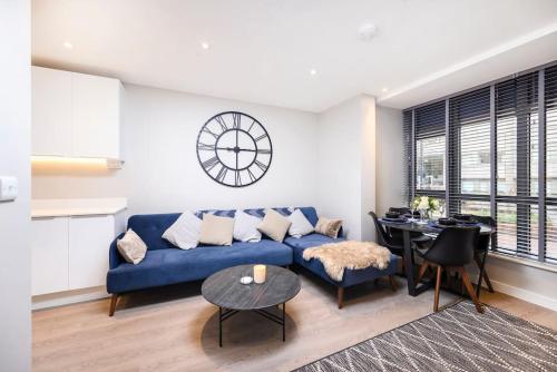 a living room with a blue couch and a table at New Modern 1 Bed Flat Great Location Piccadilly Line in Hounslow
