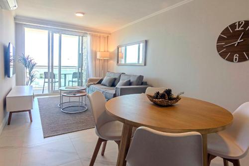 una sala de estar con una mesa y un sofá en Oceana Suites Cruceros III, en Punta del Este