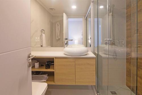 a bathroom with a sink and a glass shower at Oceana Suites en Cruceros III, con piscina interior climatizada in Punta del Este