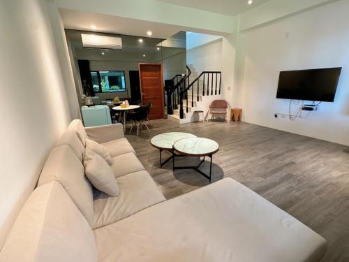 a living room with a white couch and a tv at 9 Tan Yuan Homestay in Jiaoxi