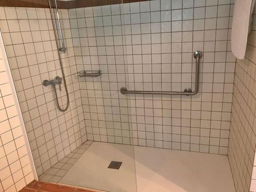 y baño con ducha y azulejos blancos. en Aricus Rural: Cal Tià en Girona