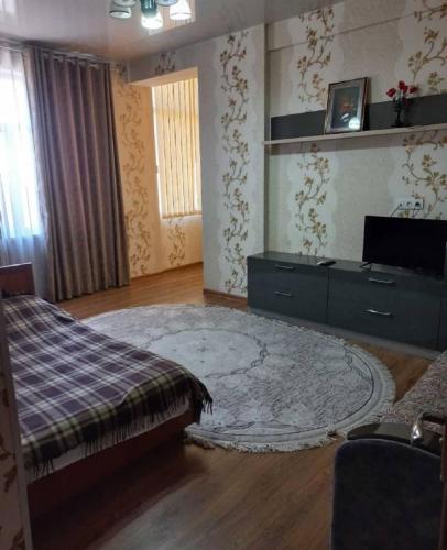 a bedroom with a bed and a dresser and a rug at Apartment near the airport - Квартира около аэропорта in Dushanbe