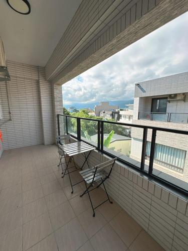 Un balcón con sillas y vista a un edificio. en 9 Tan Yuan Homestay, en Jiaoxi