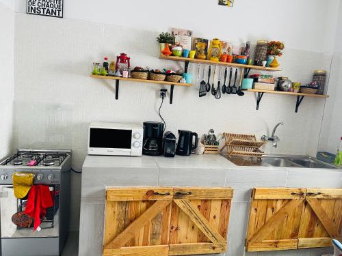 uma cozinha com um fogão e um lavatório com portas de madeira em Villa diam la paix em Guediawaye