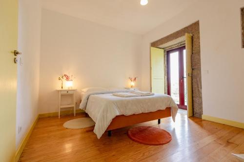 a bedroom with a bed with two lamps on it at Quinta da Cerdeira in Seia