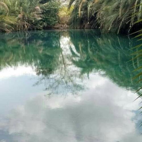 a river with a reflection of the sky in the water at Rainbow house in Boma la Ngombe