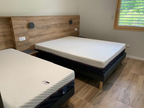 two twin beds sitting in a room with at LA VILLA NATURA in Granges-Narboz