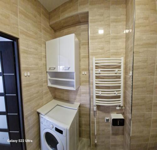 a small bathroom with a washing machine and a washer at Comfort Stay, EV, Parking in Bolesławiec