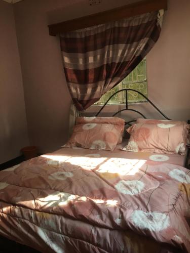 a bedroom with a bed with a window at Arusha homestay in Arusha