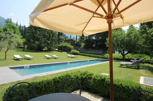 a yellow umbrella sitting next to a swimming pool at Castello di Vezio in the Village in Varenna