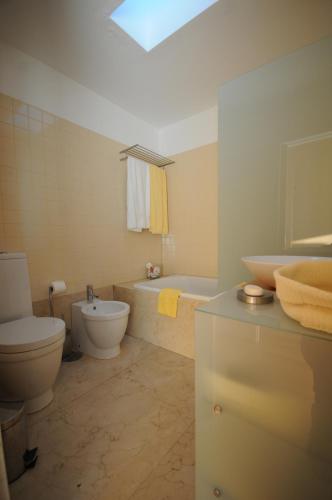 a bathroom with a toilet and a tub and a sink at Villa 257 in Caminha