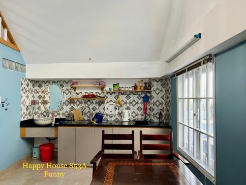 uma cozinha com papel de parede de agente da casa feliz em Căn Funny em Vung Tau