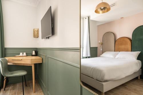 a bedroom with a bed and a desk with a chair at District Nation in Paris