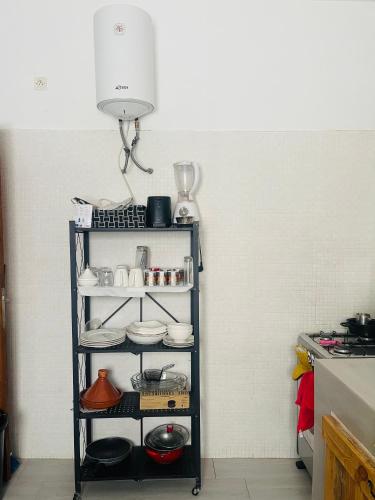 a shelf in a kitchen with dishes on it at Villa diam la paix in Guediawaye