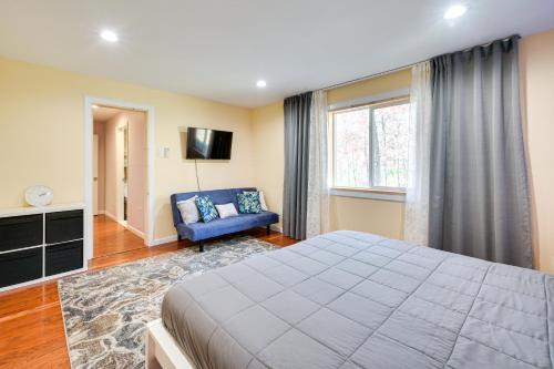 Un dormitorio con una cama grande y una silla azul. en Serene Springfield Retreat on 6 Acres with Hot Tub!, en Springfield