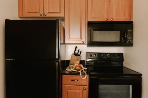 a kitchen with a black refrigerator and a microwave at The Point Universal by Edge near Epic in Orlando