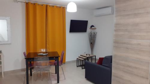 un salon avec une table et un rideau jaune dans l'établissement L'Ancestrale, Beau T2, à Limoux