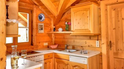 uma cozinha com armários de madeira e um lavatório numa cabina em Bio Alpenhof Rostatt em Bischofshofen