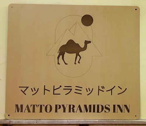 a sign with an image of a camel and mountains at Matto Pyramids Inn in Cairo
