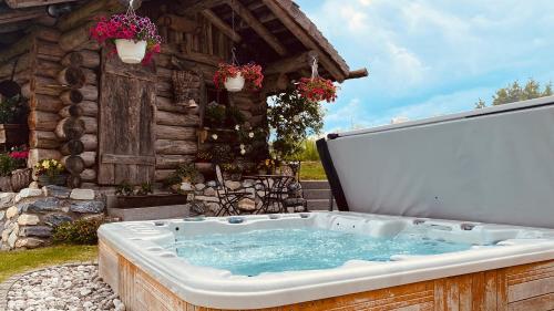 a hot tub in front of a log cabin at Bio Alpenhof Rostatt in Bischofshofen