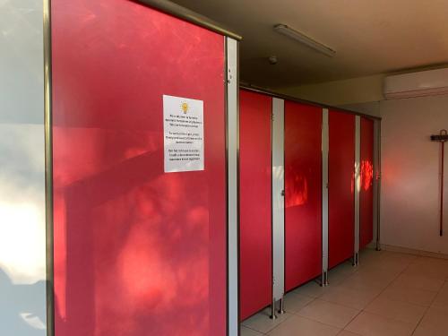 una fila de taquillas con un cartel en la puerta en Camping la Faloise, en Angicourt