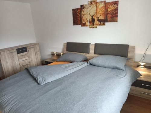 een slaapkamer met een groot bed met 2 kussens bij Appartamento Robert Arabba in Livinallongo del Col di Lana