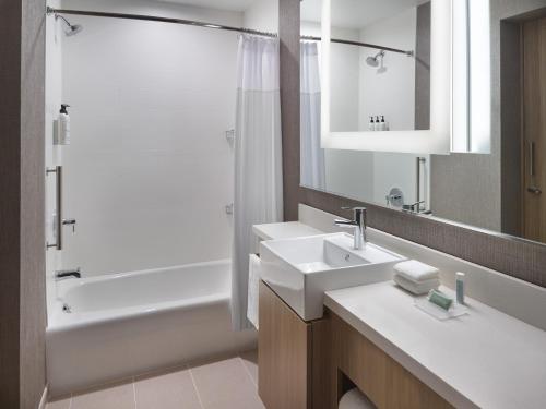 a bathroom with two sinks and a shower and a tub at SpringHill Suites by Marriott Franklin Mint in Franklin