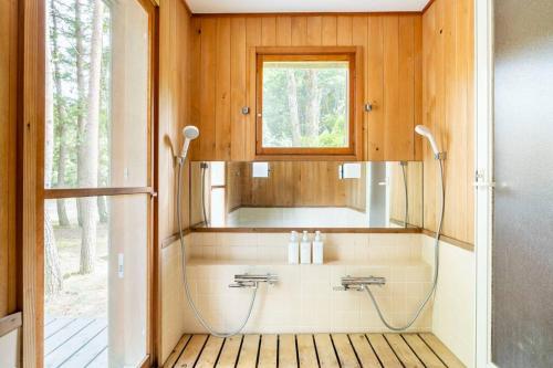ein Bad mit einem Waschbecken und einem Spiegel in der Unterkunft Private Villa J プライベートヴィラJ in Narusawa