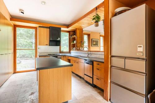 a kitchen with wooden cabinets and a refrigerator at Private Villa J プライベートヴィラJ in Narusawa