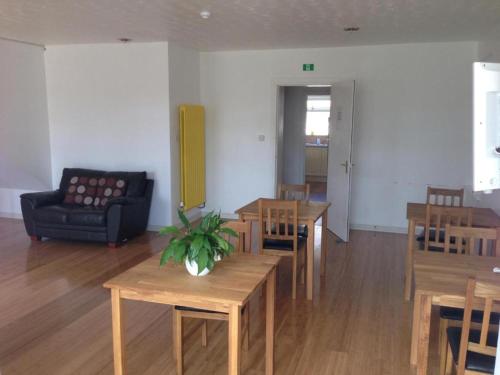 a living room with tables and chairs and a couch at Ardenlea House Hotel B&b in Dyce