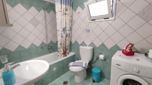 een badkamer met een wastafel, een toilet en een wastafel bij Captain's House in Sivota