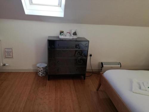 a bedroom with a bed and a dresser with a window at Ardenlea House Hotel B&b in Dyce