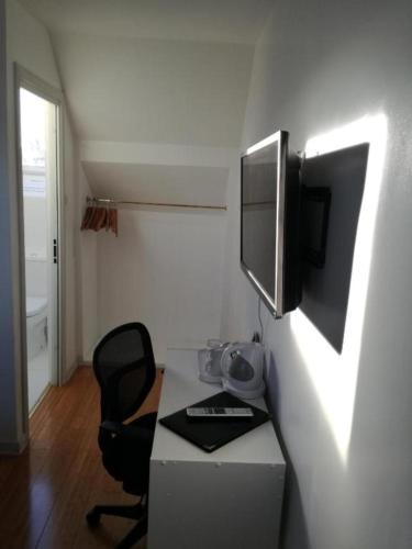 a room with a desk with a television and a chair at Ardenlea House Hotel B&b in Dyce