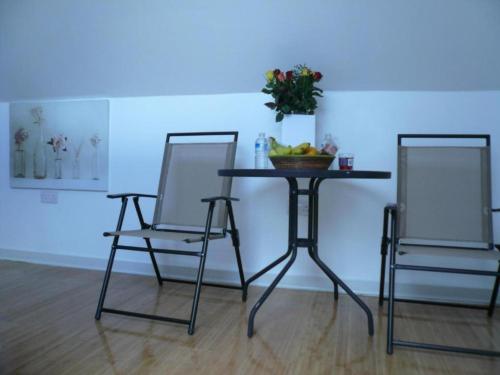 two chairs and a table with a bowl of fruit on it at Ardenlea House Hotel B&b in Dyce