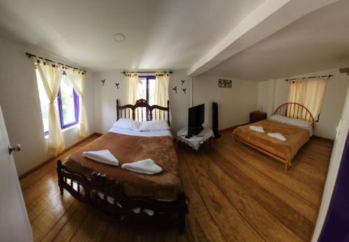 ein Schlafzimmer mit 2 Betten und einem TV in der Unterkunft Finca Hostal La Esperanza in Quimbaya