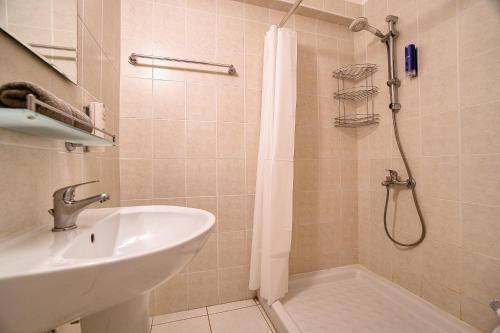 een badkamer met een wastafel en een douche met een douchegordijn bij Iris Village Block 12-105 in Paphos City