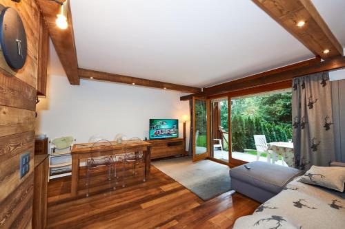 sala de estar con sofá, mesa y TV en Residence Tsaumiau, 2 bedrooms, ski lift 170m! en Crans-Montana