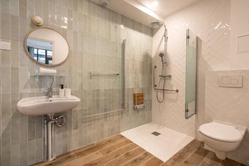 La salle de bains est pourvue de toilettes, d'un lavabo et d'une douche. dans l'établissement District Nation, à Paris