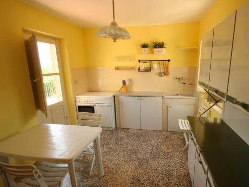 a kitchen with yellow walls and a table and chairs at Casa Vacanze Nino Petrelli in Naso