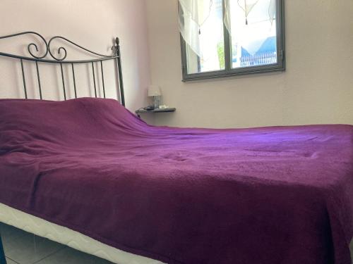 - un lit avec une couverture violette dans l'établissement Village naturiste - Port-Vénus villa n°45 avec piscine, au Cap d'Agde