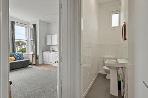 a white bathroom with a sink and a toilet at Finest Retreats - Atherfield Apartments No 5 - Sea Views in Paignton