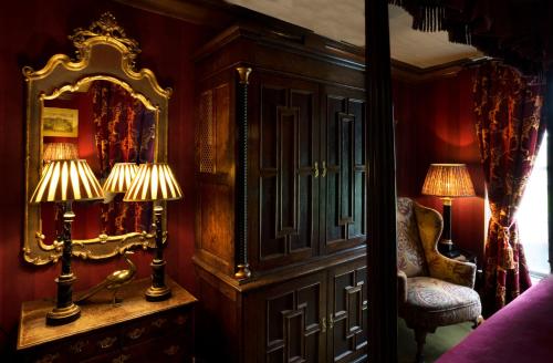 a room with a mirror and a chair and two lamps at Prestonfield House in Edinburgh