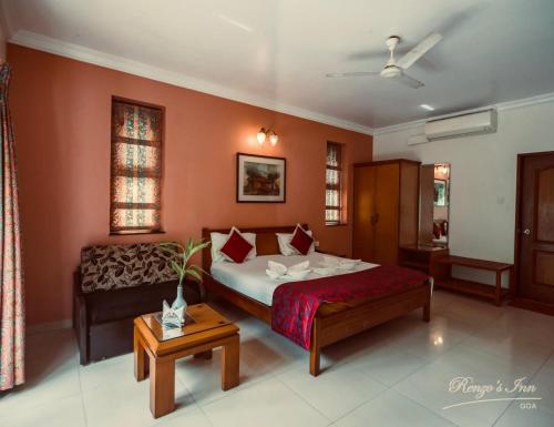 sypialnia z łóżkiem i kanapą w obiekcie Renzo's Inn w mieście Calangute