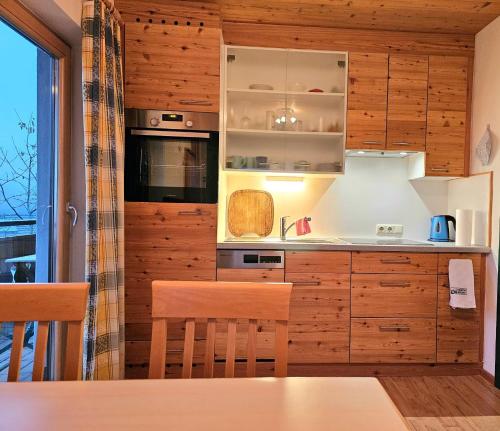 a kitchen with wooden cabinets and a table at Ferienhof Mittermair in Vorderstoder