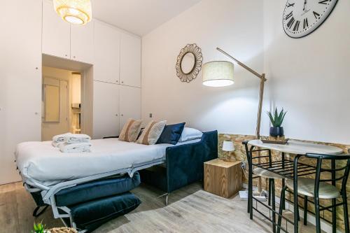 - une chambre avec un lit, une table et une horloge dans l'établissement MBA Splendide Appart - Parmentier - Paris - Proche Bastille, à Paris